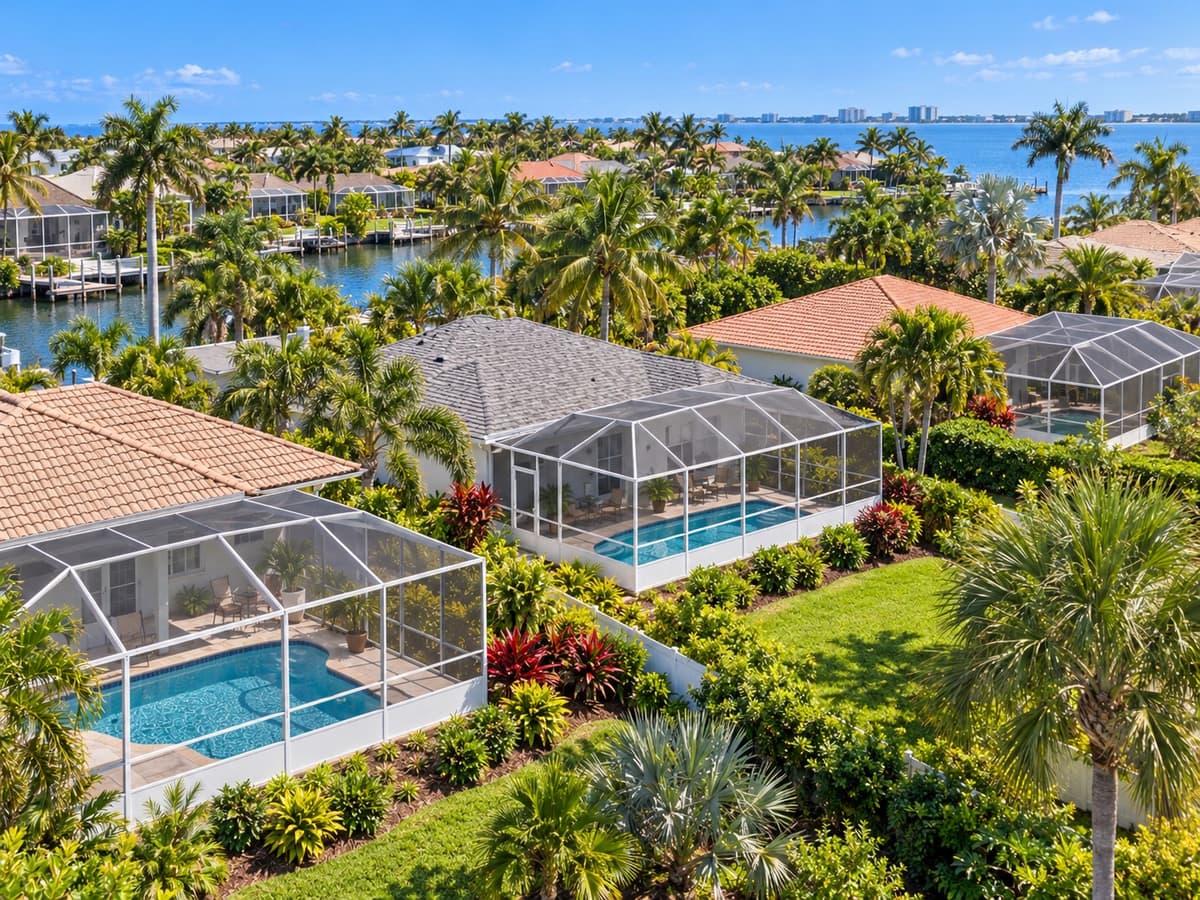 Aerial of Florida homes with pool screen enclosures near the water