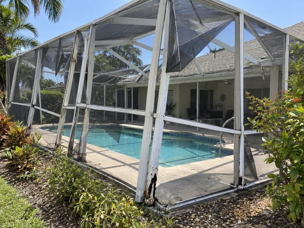 Pool cage at the end of its life with bent uprights and corroded frame